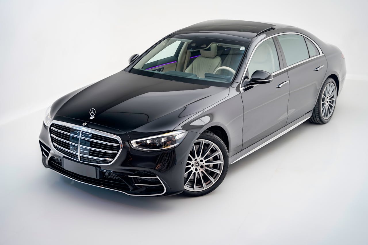 Elegant black Mercedes-Benz S Class car in a modern studio setting.