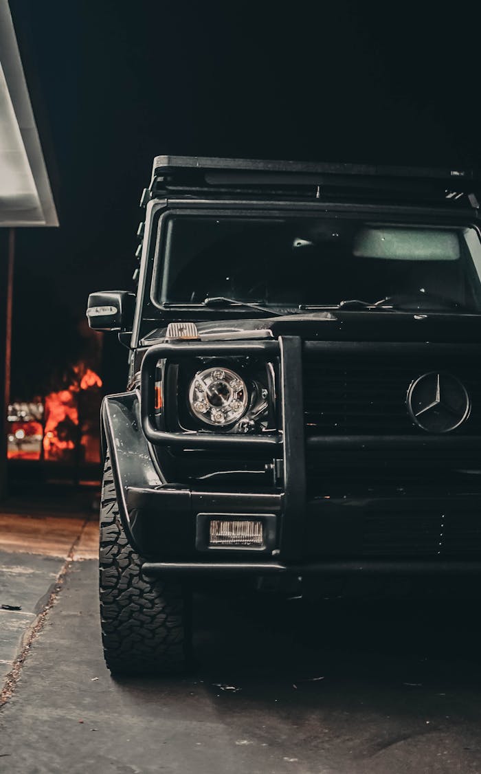 Close-up of a black luxury SUV parked outdoors at night.