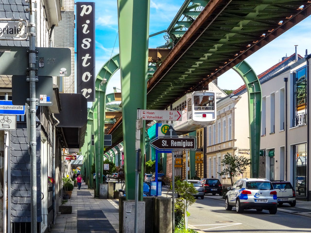 Iconic Wuppertal suspension railway above bustling urban street scene in Germany.