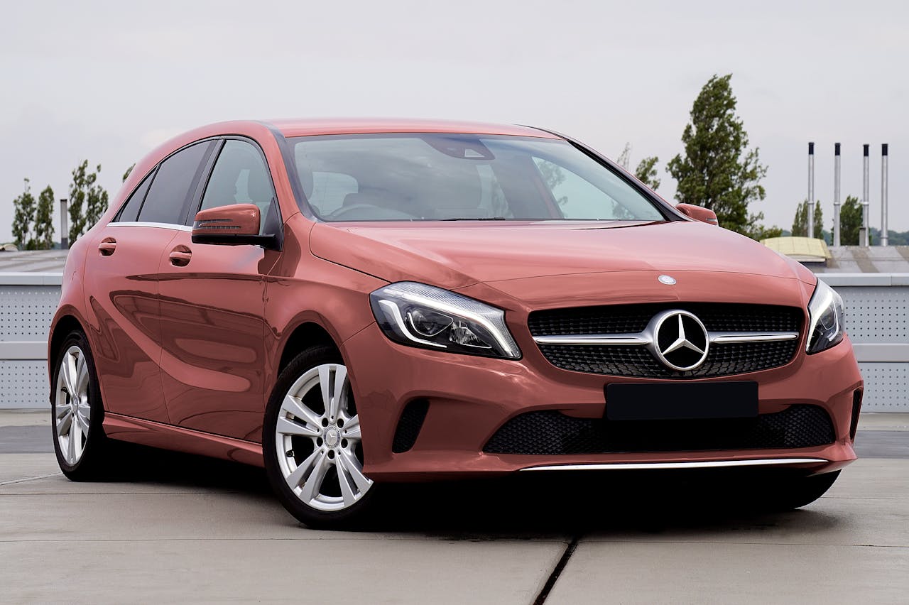 Elegant red Mercedes Benz hatchback parked outdoors showcasing luxury design.